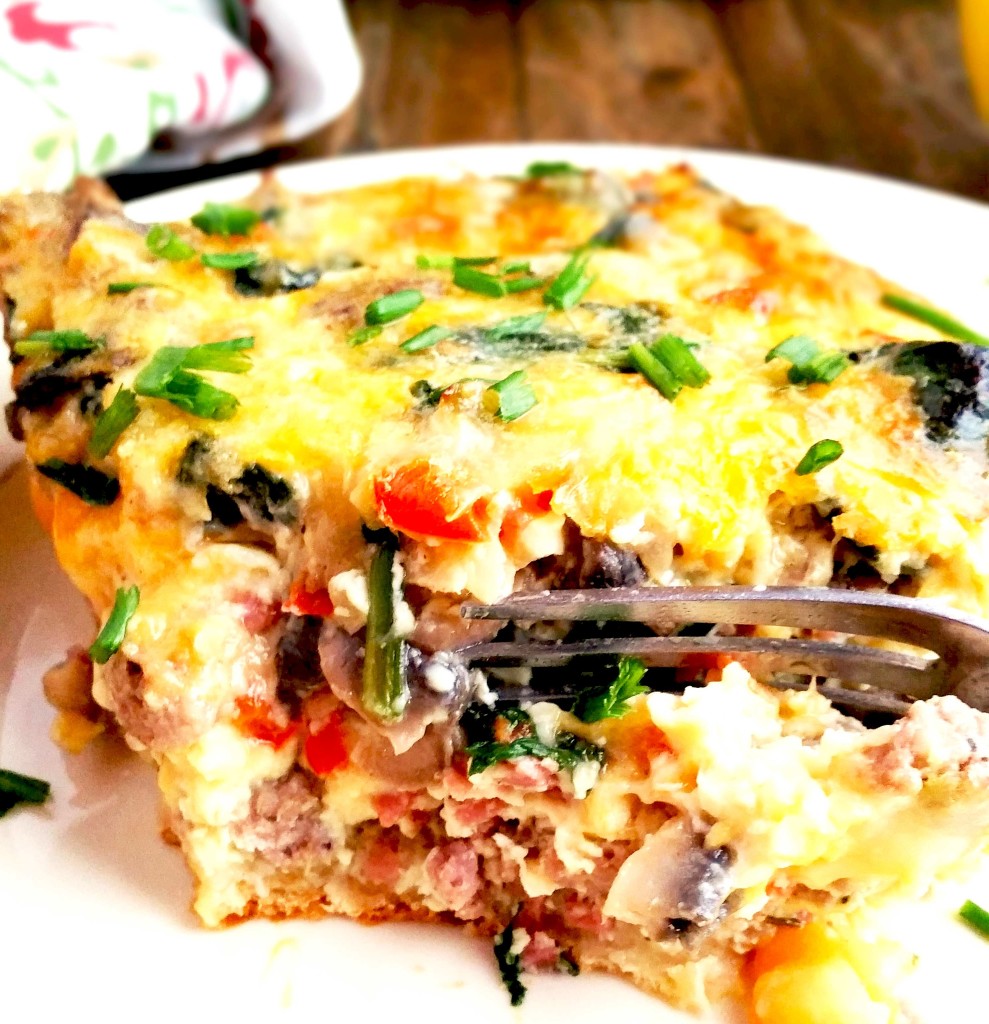 This breakfast casserole is perfect for holiday brunch! It is loaded with a crescent roll crust, sausage, bacon, mushrooms, spinach and colby jack cheese.