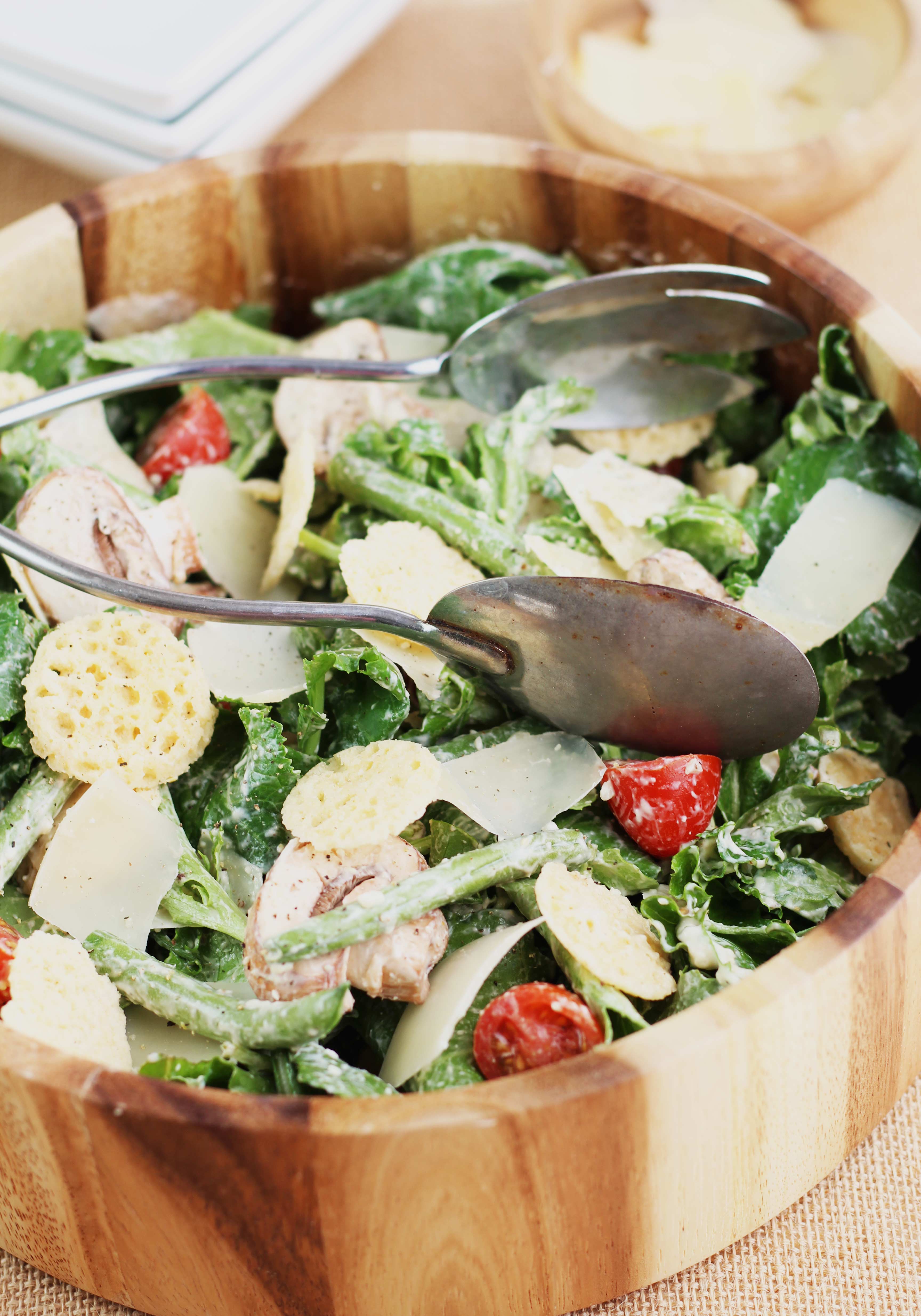A delicious and CREAMY lightened up Kale Caesar Salad with french green beans, cherry tomatoes and asiago crisps!