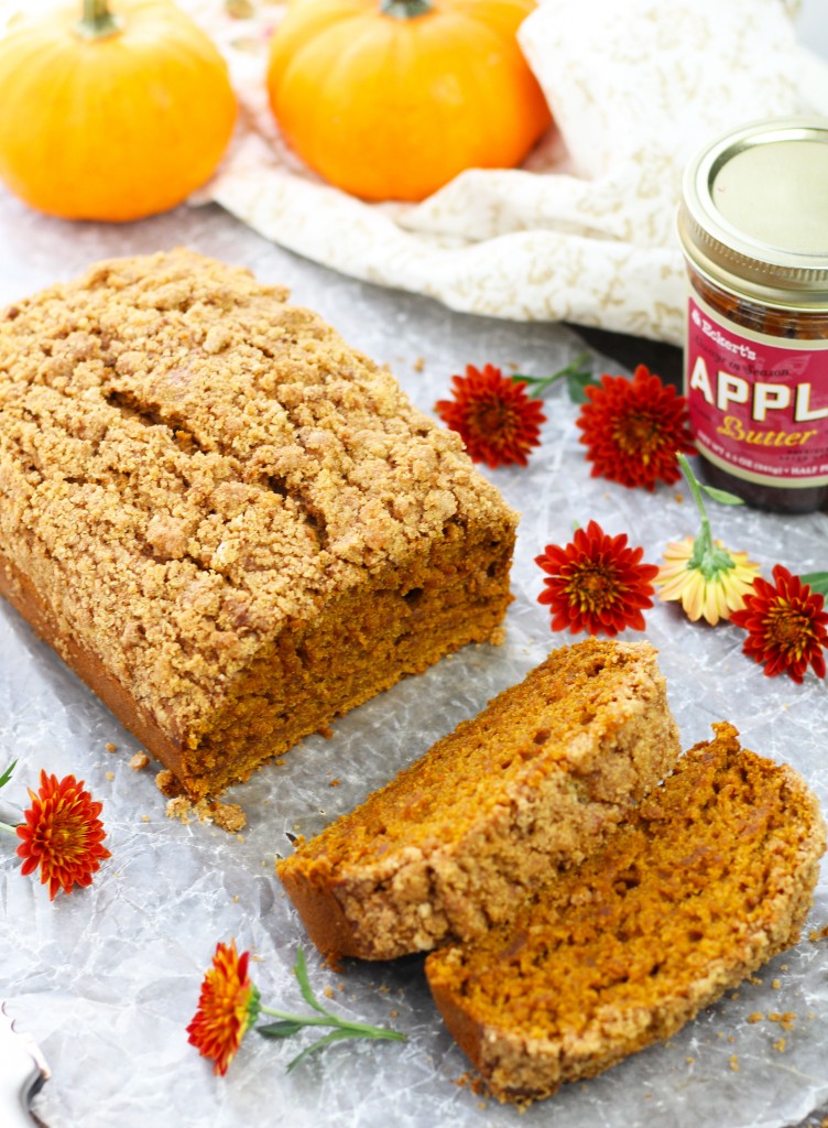 This Apple Butter Pumpkin Bread is the ultimate combination of fall flavors all in one bite.  A bit of Greek yogurt and plenty of pumpkin make this bread perfectly moist.  An easy, brown sugar crumb topping gives this bread a palatable, crunchy texture.