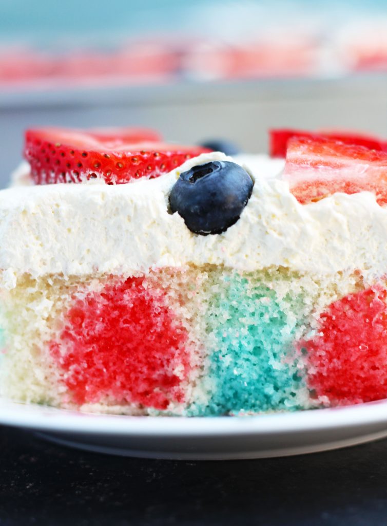 This Easy Red White and Blue Jello Cake has a cool whip and pudding icing with a berry topping.