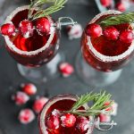 This Cranberry Mimosa gets orange liqueur and is topped with sugared cranberries and rosemary for a festive, holiday cocktail.