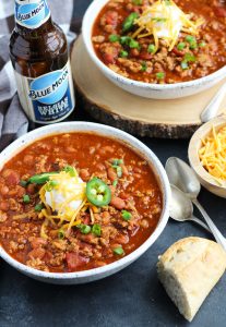 This Slow Cooker Beer Chili is easily made with ground beef or turkey.  A bottle of your favorite beer gets added with pinto beans, onion, tomato, jalapeno pepper and spices.  This recipe is perfect for game day entertaining.
