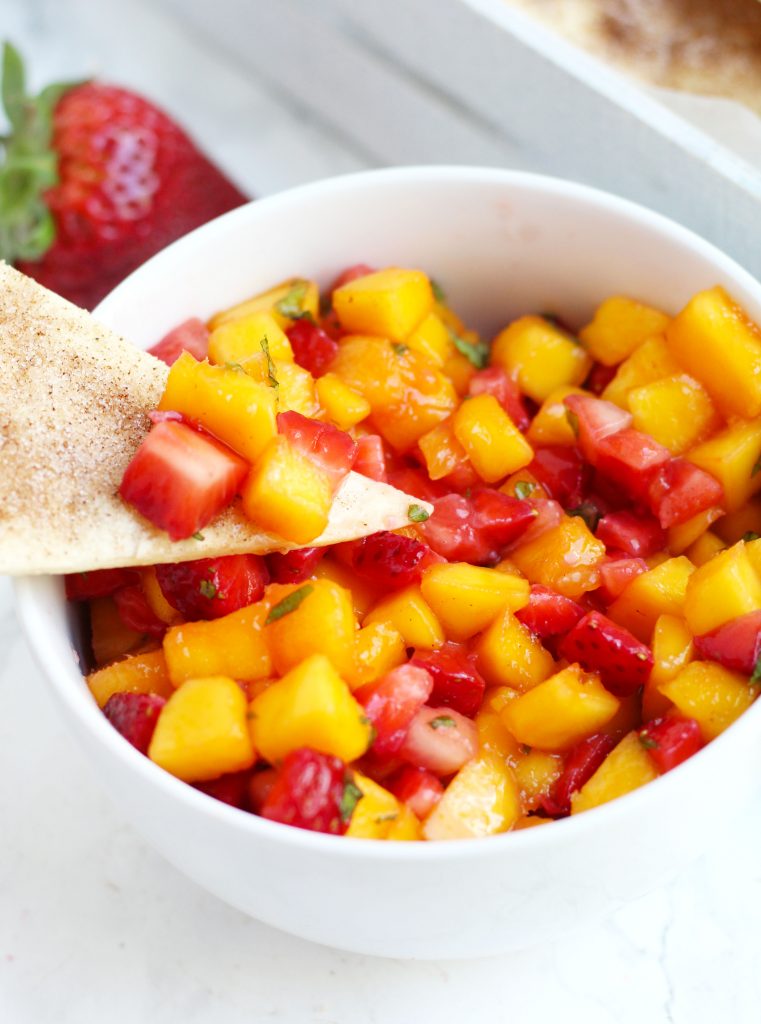 This Strawberry Mango Salsa with Cinnamon Chips is simple to make and the perfect, refreshing summertime appetizer.  Fresh strawberries and mangoes get added to this flavorful salsa with a touch of lime juice and mint.  Tortillas get brushed with melted butter, sprinkled with cinnamon and sugar, and cut into triangles before baking into a crispy chip.