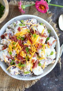 This Loaded Potato Salad is a great, easy side dish for your summer barbecues.  It tastes like biting into a potato skin with a sour cream and ranch dressing mixture and that coveted bacon, cheddar cheese and green onion topping.  