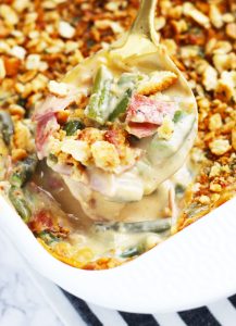 This Cheesy Bacon Green Bean Casserole has so much more flavor than the traditional cream of mushroom soup version. Plenty of Velveeta and Colby Jack cheese gets added to this cheesy sauce with a pack of bacon and crispy, cracker topping.  