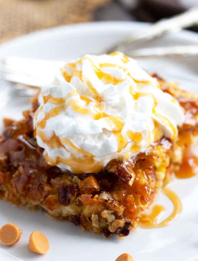 This easy, Pumpkin Dump Cake is sure to be a hit this fall.  Vanilla cake mix is used as the base with pumpkin, evaporated milk and a pecan and butterscotch chip topping.  Serve it warm with whipped cream and a caramel sauce topping for a truly decadent treat.
