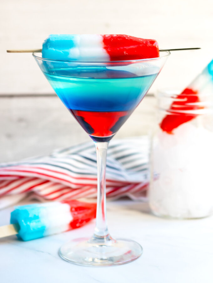 This Bomb Pop Martini has layers of red, white and blue that make a perfect martini for the 4th of  July or Memorial Day.  The fun, patriotic appearance is achieved with Bacardi Limon with pineapple juice, Blue Curacao and Grenadine.